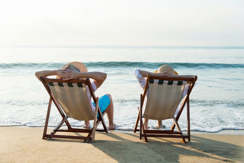 people sat on deckchairs on beach